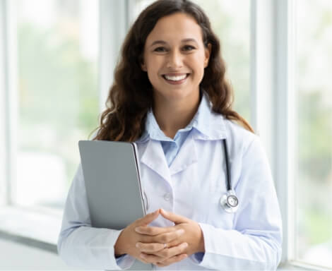 woman-doctor-standing-by-window-holding-laptop-2024-01-09-07-12-14-utc (1)
