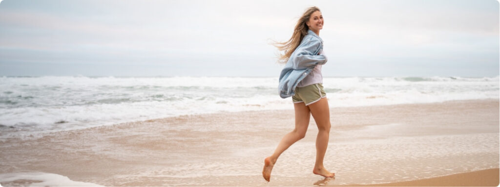 happy-woman-in-casualwear-running-on-wet-seashore-2024-12-13-16-03-13-utc (1)