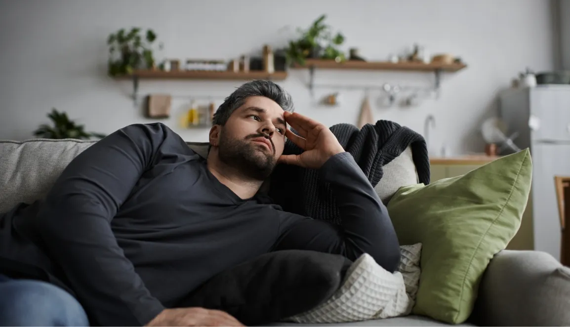 handsome man relaxing thoughtfully on a cozy couch utc