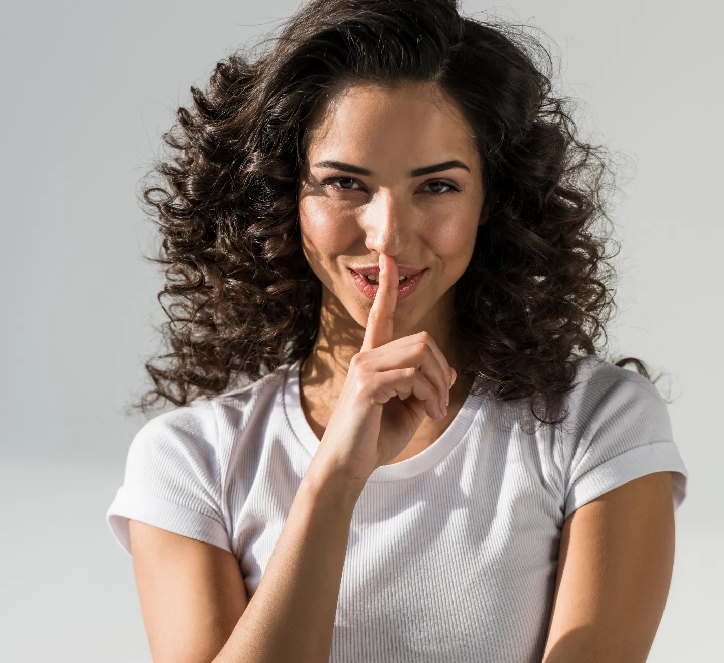 sensual curly girl touching lips with finger on gr utc